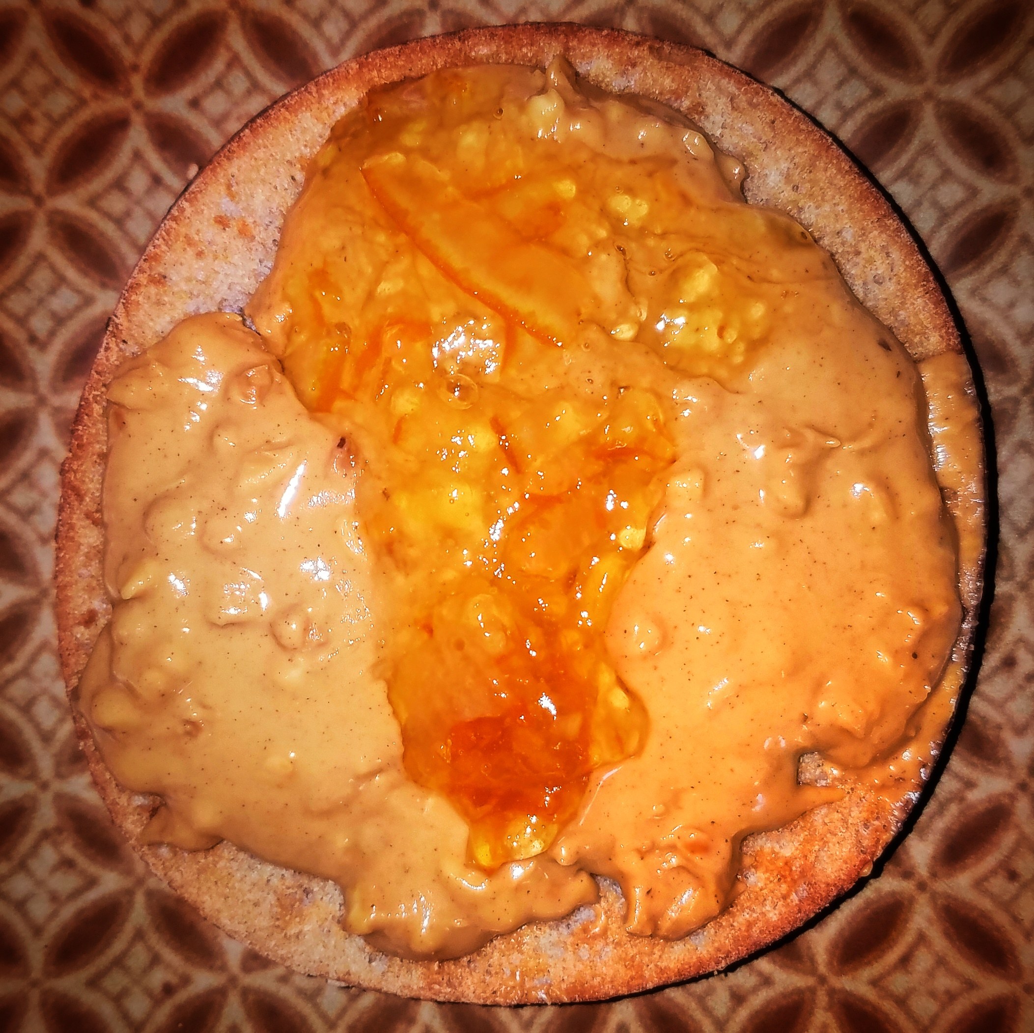 Ein leicht getoastetes Sandwich, das dick mit Erdnussbutter bestrichen ist, auf einem Teller.