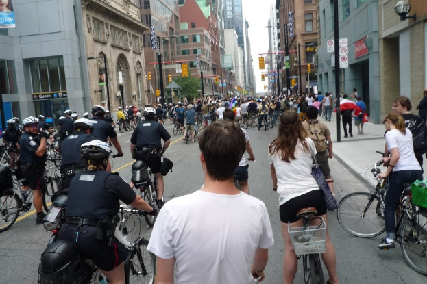 Gebäude mit wenigen Menschen, die Fahrräder auf einer Straße fahren.