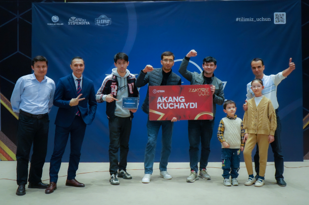 Ein buntes Plakat mit einem blauen Hintergrund und gelben und weißen Buchstaben, die 'Gewinner' in fetter Schrift lesen, mit lachenden Menschen in der Mitte.