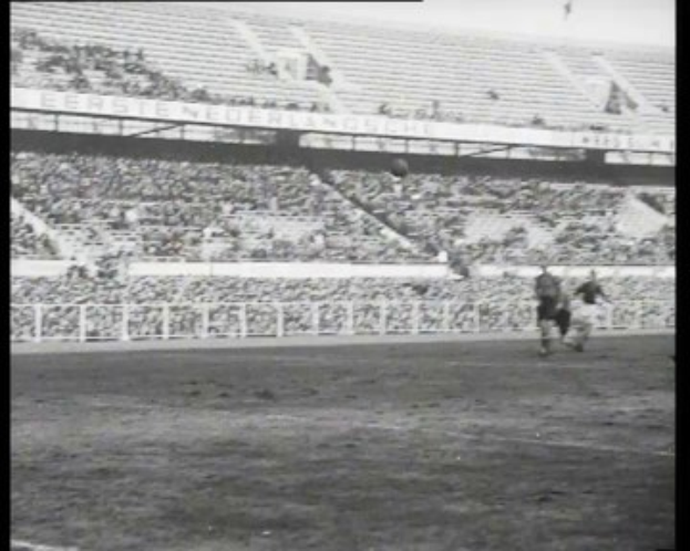 Schwarzes und weißes Foto eines Fußballspiels in einem Stadion, mit Spielern auf dem Feld und Zuschauern auf den Tribünen, beschriftet mit "1961-1962 Niederländische Fußball-Meisterschaft."
