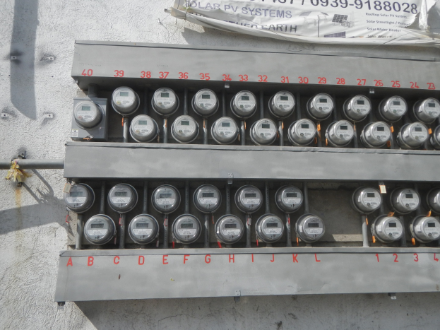 Nahaufnahme eines Stromzählers an der Seite eines Gebäudes mit einem Banner mit Text oben