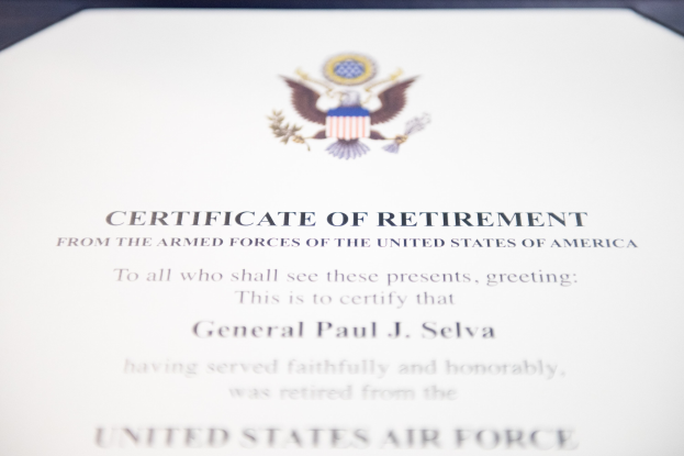 Rahmenurkunde für den Ruhestand der United States Air Force mit blauem Rand, die ein zentrales Sternschild-Logo innerhalb eines Lorbeerkranzes und eine 'Ruhestand'-Banderole zeigt, alles in Schwarz gedruckt.