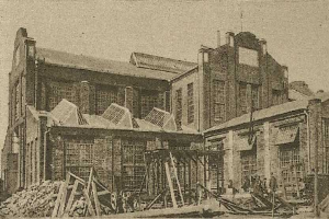 Schwarz-weiß-Fotografie von Sydney Central Railway Station während der Bauarbeiten, mit Holzmaterialien, einem Karren und einem Himmel im Hintergrund.