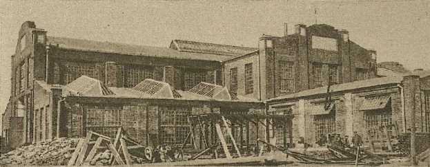 Schwarz-weiß-Fotografie von Sydney Central Railway Station während der Bauarbeiten, mit Holzmaterialien, einem Karren und einem Himmel im Hintergrund.