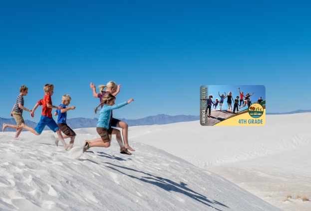 Kinder laufen über eine weiße Sanddüne im Death Valley National Park mit Hügeln und einem klaren blauen Himmel im Hintergrund, neben einer Werbung für ein 4. Schuljahr-Abenteuer auf der rechten Seite.