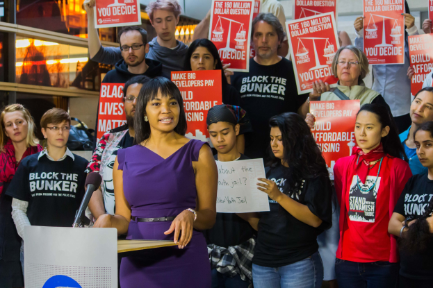 Aktivistin von Black Lives Matter spricht vor Publikum mit Mikrofon.