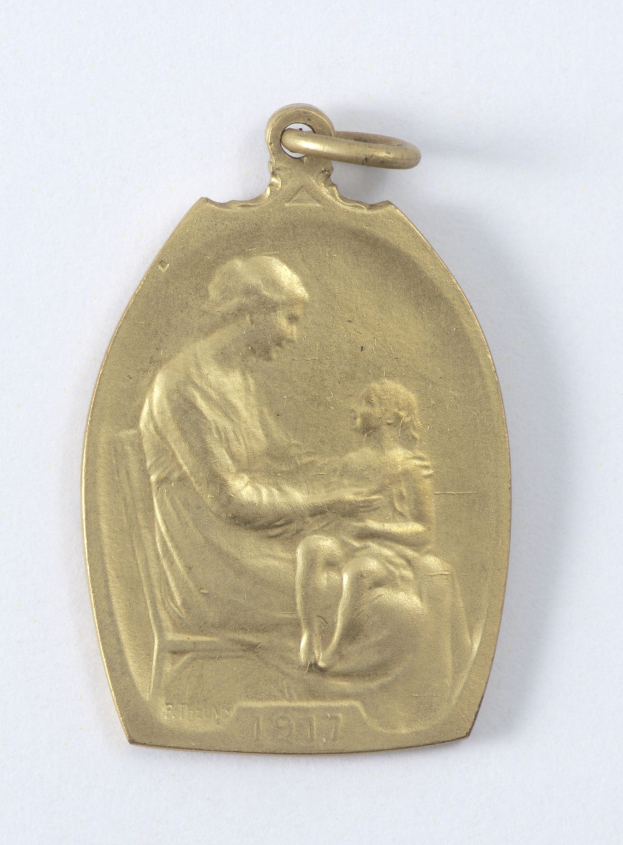 Goldmedaille mit Relief einer Frau in weißem Kleid mit Haarknoten, die ein Kind hält, beide schauen sich zärtlich an, beschriftet mit 'Mutter und Kind' in Kursivschrift.