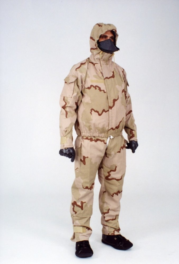Mann in einem Tarnmuster-Schutzoverall und Kapuze mit Gesichtsmaske vor einem weißen Hintergrund.