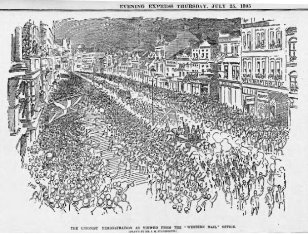 Schwarze und weiße Illustration einer Menge, die eine Straße zwischen Gebäuden entlanggeht, mit Text oben und unten: "Die Unionistendemonstration aus der Sicht des Western Mail Office".