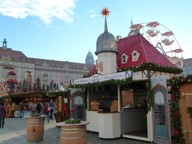 Ein pulsierender Weihnachtsmarkt in Nürnberg, Deutschland mit festlichen Ständen, Menschen, einem Riesenrad, Gebäuden und einem Schild im Hintergrund.