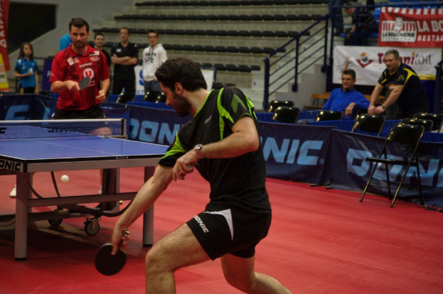 Gruppe von Menschen in verschiedenen Kleidungsfarben in der Nähe von Stühlen, einer Treppe, einem Tisch mit einem Spiel und einem Ball.
