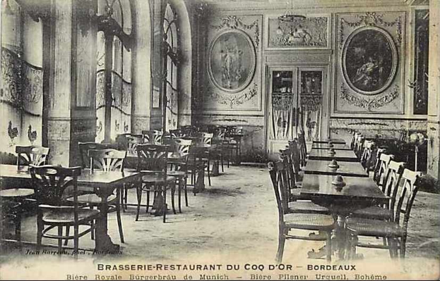 Schwarz-weiß-Foto eines leeren Brasserie-Restaurant-Interieurs im Coq d'or, Bordeaux, Frankreich, mit Tischen, Stühlen, Wandgemälden und einer zentralen Tür.