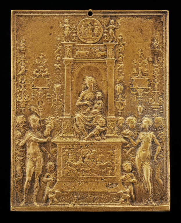 Goldene Plakette mit detaillierten Skulpturen einer Frau in einem langen Kleid und eines Mannes in einem Anzug, eingerahmt von einem goldenen Rand, vor einem schwarzen Hintergrund.