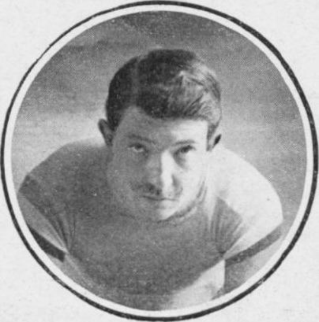 Schwarzes und weißes Foto eines Mannes in einem Fußballtrikot mit ernstem Gesichtsausdruck, der eine Fußballuniform trägt und kurze dunkle Haare hat.